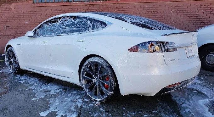 White Tesla Model S covered in snow foam during a mobile detail in Phoenix
